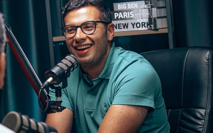 Anthony Miranda sorrindo durante a gravação de um podcast.